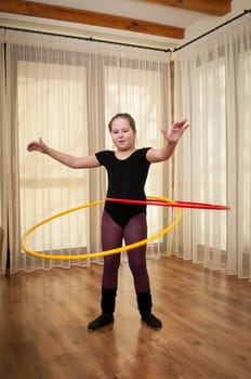 Young girl show gymnastics dance with hoop at home