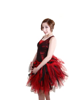 Lovely young teenager in a red and black ballet dress with a very big twill skirt standing in the studio for white background.