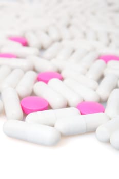 Medical Pink Pills and White Capsule On White Background