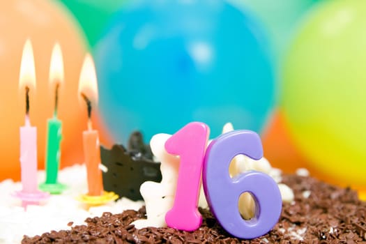 Sweet Sixteen Birthday Cake, candles and balloons.
