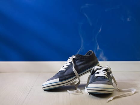 concept shot of feet perspiration: bad smell coming out from old and dirty shoes