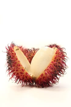 four rambutan fruits against white background