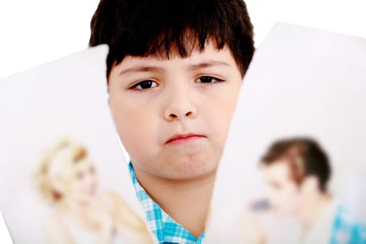 Upset boy standing in front pcture of parents with problems against white background