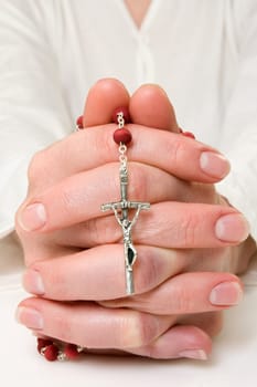 Close up of female hands praying with rosary