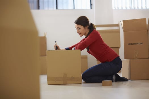 mid adult happy woman during move with boxes at new flat and packing carton
