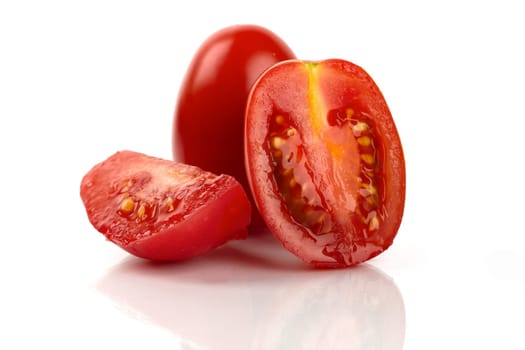 Fresh Roma tomatoes cut against white background