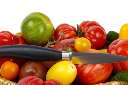 Numerous biotomets in basket with knife against white background