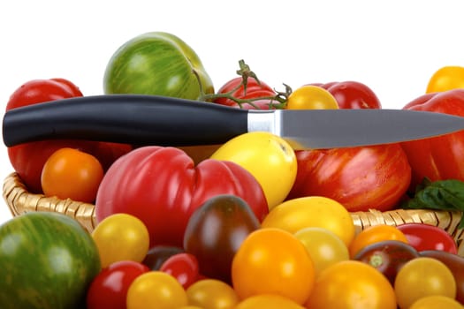 Numerous biotomets in basket with knife against white background