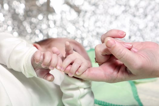 mother touch hand with newborn
