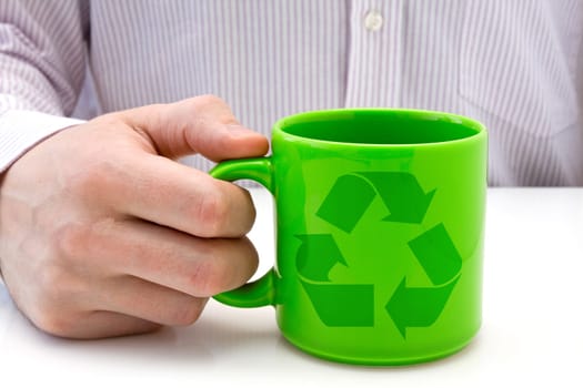 hand hold a green cup with recycled symbol