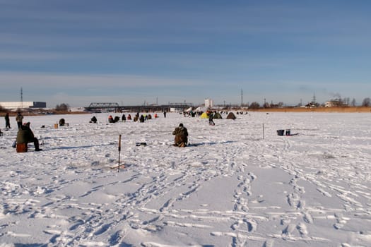 ice fishermens fishing on a frozen river