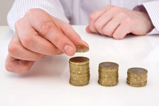 human hand putting coin to money staircase