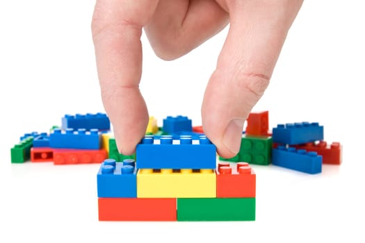 close-up of hand building a color plastic bricks