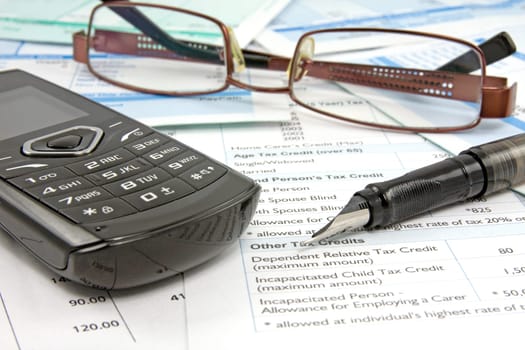 Financial reports with pen,mobile phone and glasses