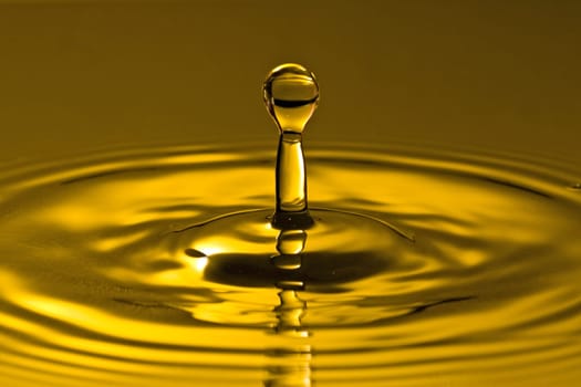 close-up of droplet splash in a golden water