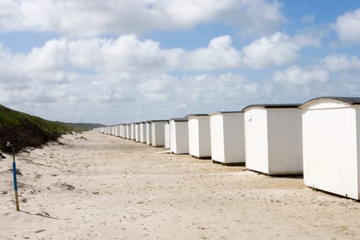 Row of White boathouses on the beach