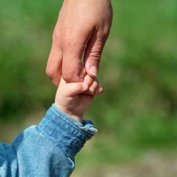 Mother and young son holding hands