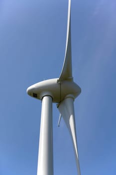 Close-up of a wind turbine in front of a blue sky
