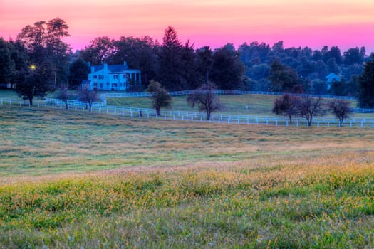 Sunset behind the rolling hills on a horse farm in Kentucky