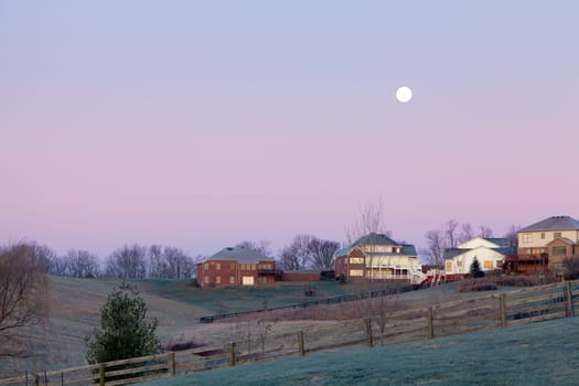 Moon setting over a suburban residential neighborhood