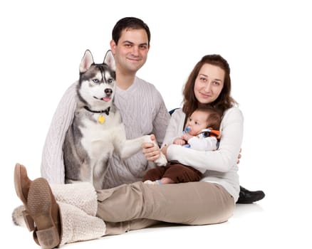 Portrait of a young family and their pet dog on white background