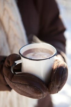 Mug of hot chocolate outdoors on a winter day