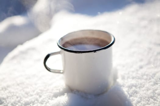 Mug of hot chocolate outdoors on a winter day in snow