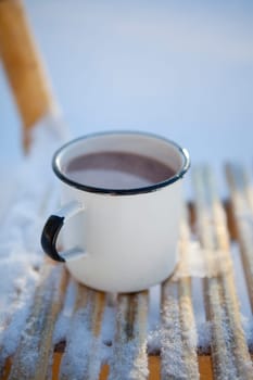 Mug of hot chocolate outdoors on a winter day on a wooden sled