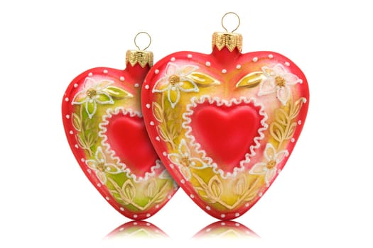 two hearts shaped baubles with reflection on white