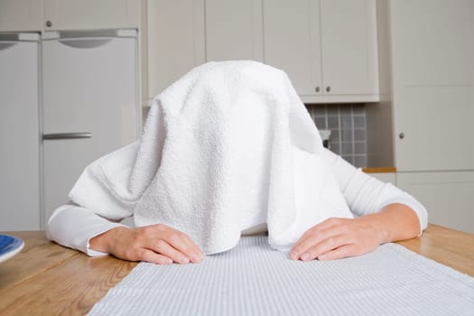 Cold woman with a towel at home