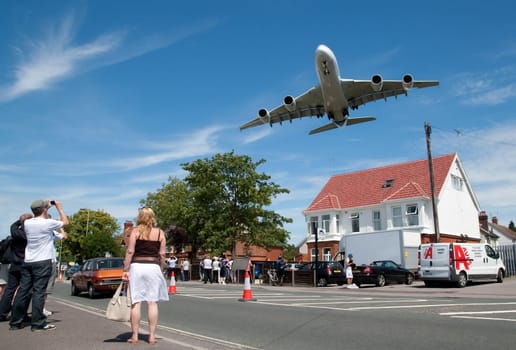 Massive Airbus A380 aircraft on landing approach over local suburban street during the Farnborough International Airshow, hampshire, UK - July 19, 2010