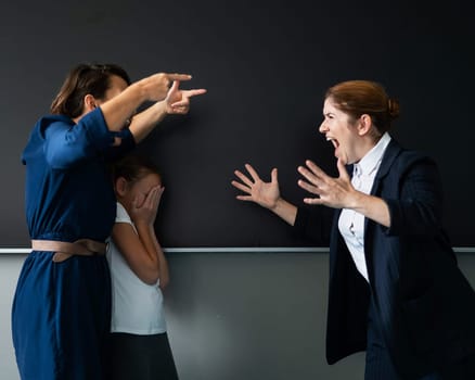 A female teacher and a student's mother yell at each other at the blackboard. The schoolgirl is crying