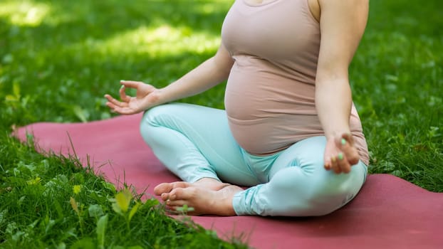 Prenatal yoga. Caucasian pregnant woman doing butterfly pose in the park