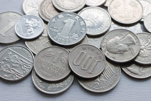 Many different coins, different denominations and colors, top view.