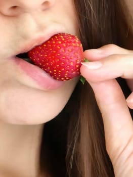 Girl bites strawberry, sensual lips and strawberry close-up