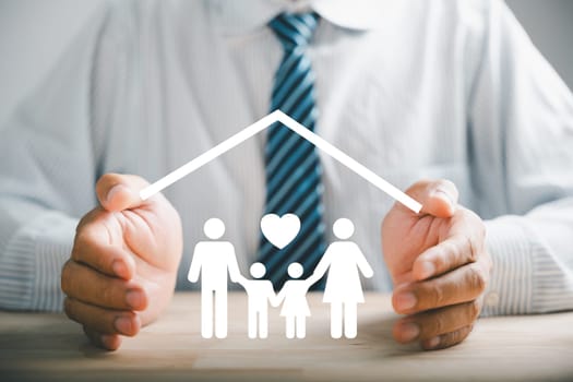 Security and family insurance concepts. Businessman protective gesture by family silhouette. Icons for family, life, health, and house insurance. Depicting insurance concept.
