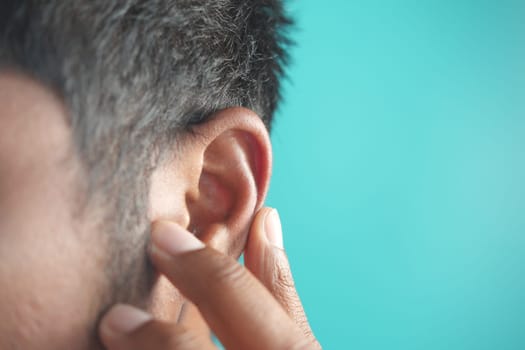 young man having ear pain touching his painful ear