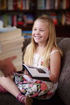 Reading, stack of books and child in library with smile, learning and relax on sofa with study knowledge. Storytelling, happy girl in bookstore with story collection in fantasy and education on couch.