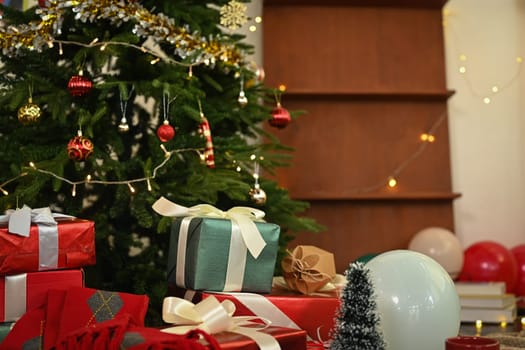 Beautiful decorated Christmas Tree with gift boxes on floor in living room. Winter holiday celebration concept.