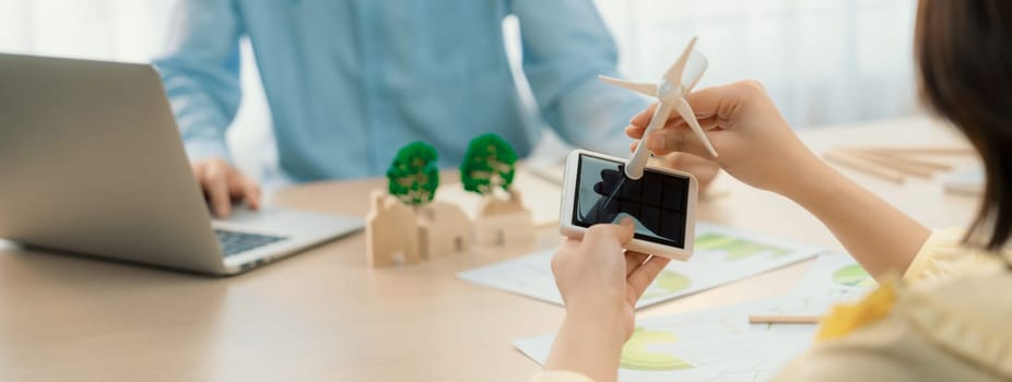 Businesswoman interested in investing in renewable energy at meeting table with environmental document scatter around. Business team discussion about green business project. Closeup. Delineation.