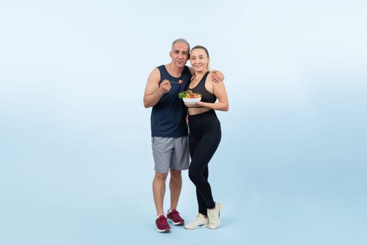 Happy smile senior man and woman portrait holding bowl of vegan fruit and vegetable on isolated background. Healthy senior couple with healthy vegetarian nutrition and body care lifestyle. Clout