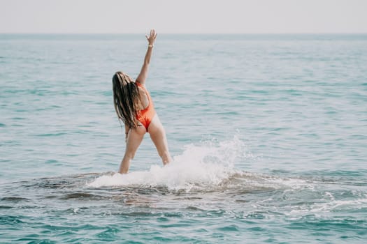 Woman sea yoga. Back view of free calm happy satisfied woman with long hair standing on top rock with yoga position against of sky by the sea. Healthy lifestyle outdoors in nature, fitness concept.