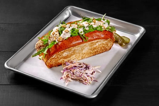 Sandwich in toasted brioche bread filled with crispy breaded chicken fingers, fresh tomatoes, cucumbers and spinach topped with light mayo and chopped cashews served with pickles and shredded cabbage