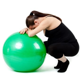 Pregnant woman excercises with gymnastic ball.