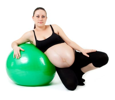 Pregnant woman excercises with gymnastic ball.