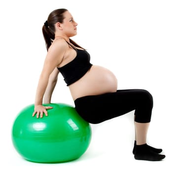 Pregnant woman excercises with gymnastic ball.