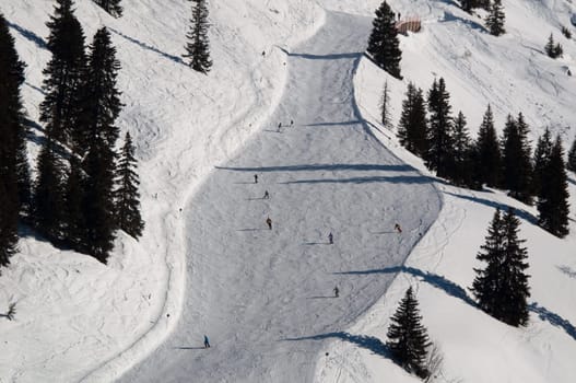 Snow covered ski piste surrounded by trees on sunny day at Montafon, Austria
