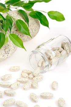Herbal supplement pills spilling out of bottle - alternative medicine concept