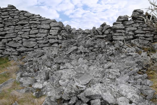 rocky boundary walls in scenic west ireland with a cloudy background