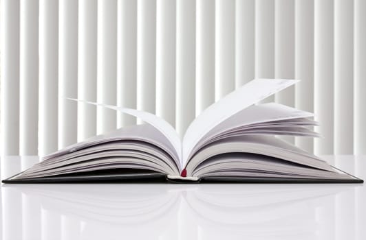 education concept. opened book with reflection on white